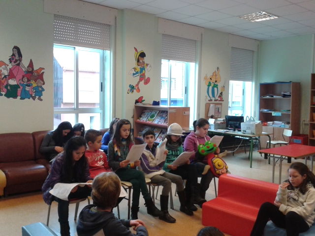 Nenos e nenas lendo contos na biblioteca no club de lectura
