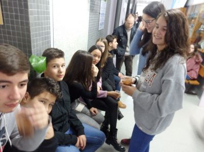 Alumnos e alumnas de 2º e 3º, departindo mentres saborean un vaso de chocolate.
