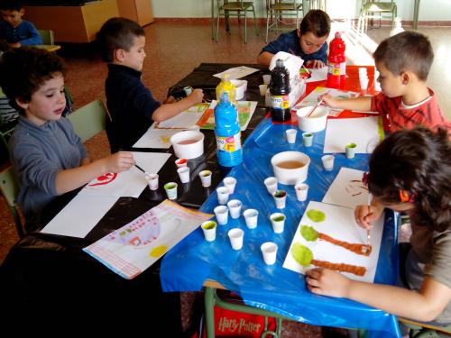 nenos de primeiro pintando o redor dunha mesa