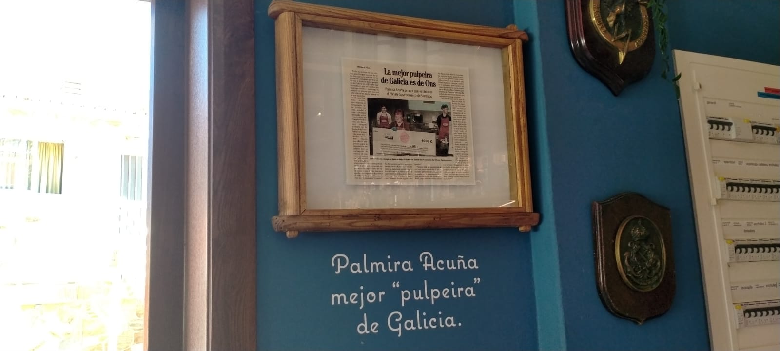 Foto da placa acreditativa do nomeamento de Palmira como mellor pulpeira de Galicia