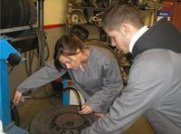 María y Lorenzo inflando una rueda de un vehículo.