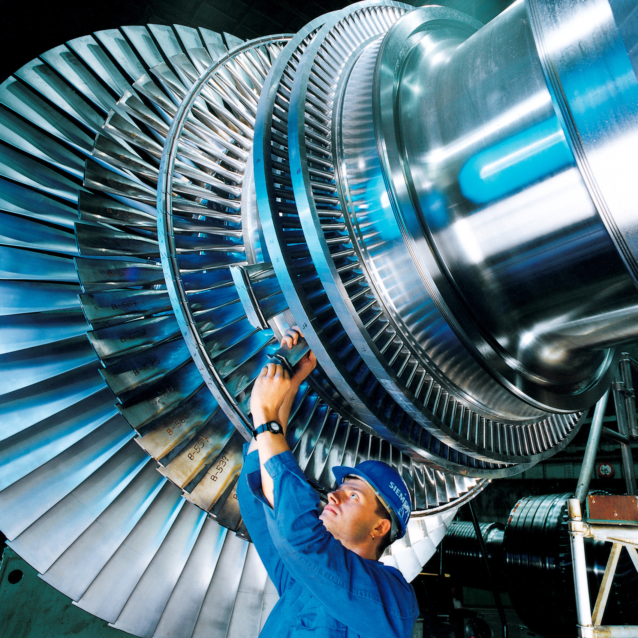 Foto de un operario trabajando en una turbina de una central eléctrica.