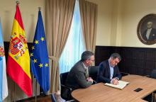 Román e o alcalde de Ribadeo asinando un acordo