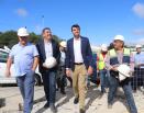 Román e un grupo de persoas paseando por unha obra