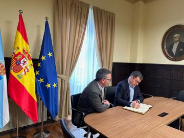 Román e o alcalde de Ribadeo asinando un acordo